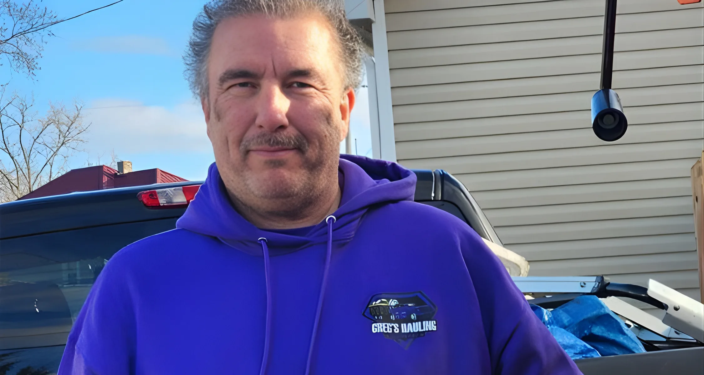 Greg of Greg's Hauling beside a loaded truck